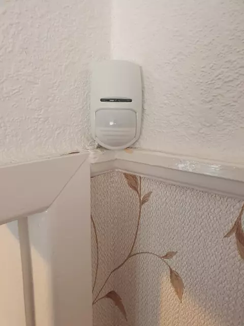 A motion sensor fitted in the corner of a room